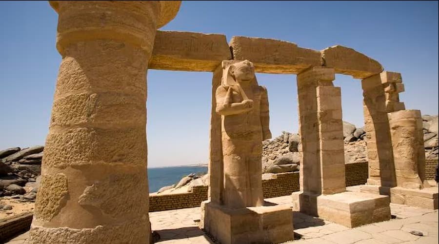 Tourists visiting the Temple of Kalabsha in Aswan, Egypt, with detailed stone carvings